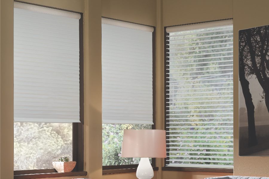 Opaque motorized window shades in Sacramento keep hot UV rays out of your home. Gray motorized sheer shades on corner windows next to gray furniture
