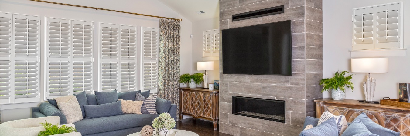 Plantation shutters in Caramichael living room with fireplace