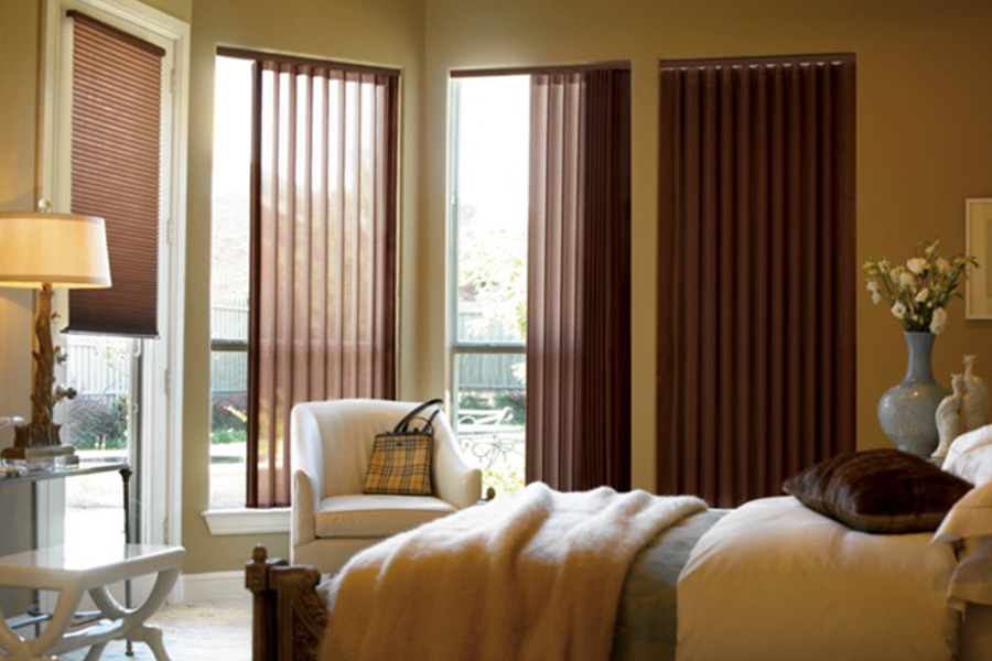 Choose durable and high-quality fabric or vinyl vertical blinds in Sacramento. Maroon fabric vertical blinds inside a bedroom
