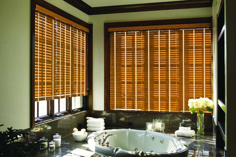 Premium quality blinds are always a stylish accent in your Sacramento home. Brown wood blinds on large windows in a green bathroom