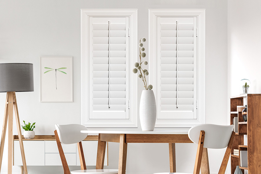 Sunburst's selection of stylish window treatments for designers in Sacramento makes it easy to find the perfect ones for every design job.  White Polywood shutters on two windows in a modern Scandinavian-style room