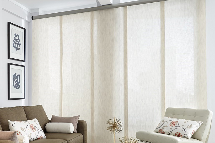 Find window treatments to complete any interior design among our extensive selection at Sunburst Shutters Sacramento.  Long off-white window shades on a tall window in a modern living room