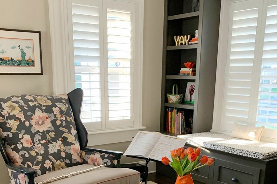 Elegant Polywood interior shutters are beneficial and stylish in a cozy home library. Photo credit: MeaghanBMurphy  White Polywood shutters in a cozy and small living room with a bookshelf in the corner.