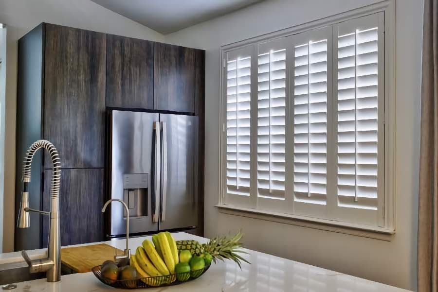 Homeowners use indoor window shutters in Sacramento when they want attractive and functional window treatments. Polywood shutters on a large kitchen window