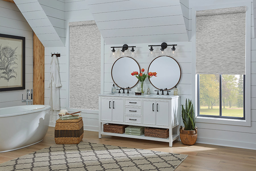 Slim-profile roller shades easily fit shallow windows in your Sacramento home. Gray patterned roller shades on bathroom windows